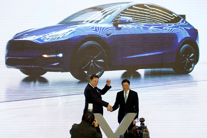 Tesla Inc CEO Elon Musk speaks next to a screen showing an image of Tesla Model 3 car during an