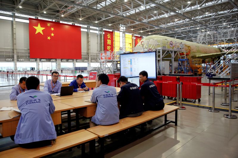 FILE PHOTO: Employees work on a China's home-grown C919 passenger jet at Manufacturing and