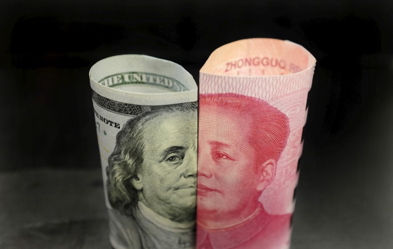 FILE PHOTO: A Benjamin Franklin U.S. 100 dollar banknote and a Chinese 100 yuan banknote with