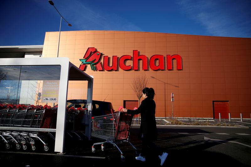 FILE PHOTO: A customer pushes a shopping cart at Auchan supermarket in Noyelles-Godault