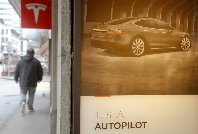 FILE PHOTO: Advertisement promotes Tesla Autopilot at a showroom of U.S. car manufacturer Tesla