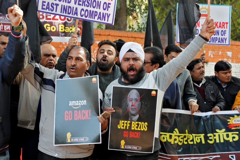 Members of the Confederation of All India Traders hold placards during a protest against the