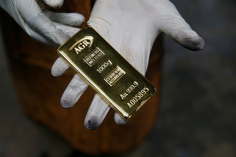 An employee holds a 1kg gold bar at AGR (African Gold Refinery) in Entebbe