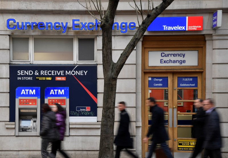 People walk past a branch of Travelex Currency Exchange in London