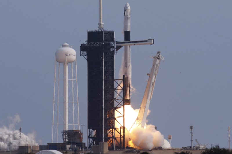 A SpaceX Falcon 9 rocket, carrying the Crew Dragon astronaut capsule, lifts off on an in-flight