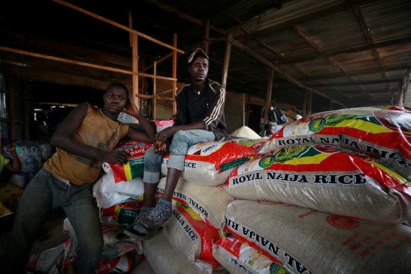 Workers rest on stacks of processed rice at Wurukum Rice Mill in Makurdi