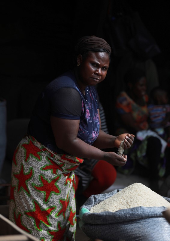 A woman selling rice runs grains through her fingers at Wurukum Rice Mill in Makurdi