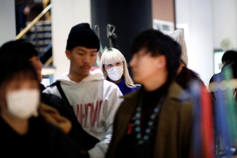 Tourist wears a protective mask at a duty free shop in Paris as the country is hit by the new