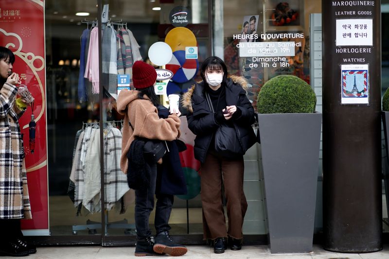 Employee of an empty duty free shop is pictured in Paris as the country is hit by the new