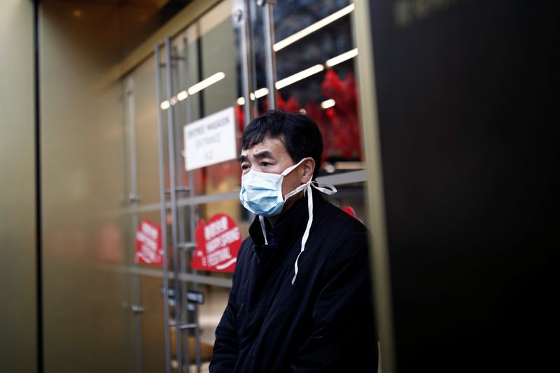 Tourist wears a protective mask in front of the Galeries Lafayette department store in Paris as