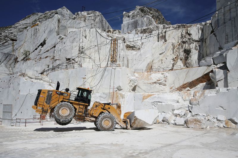 FILE PHOTO: A Caterpillar bulldozer transports a marble stone at the Cervaiole marble quarry on