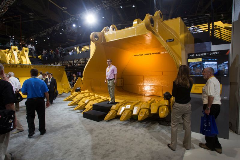 FILE PHOTO: Dmitry Golitsyn of Moscow stands in a new latchfree dipper at the Caterpillar booth