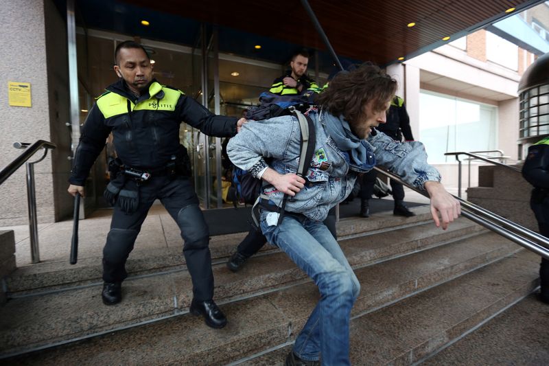 Activists block the entrance of the Shell headquarters in The Hague