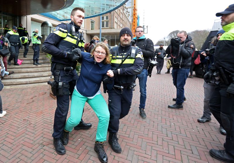Activists block the entrance of the Shell headquarters in The Hague