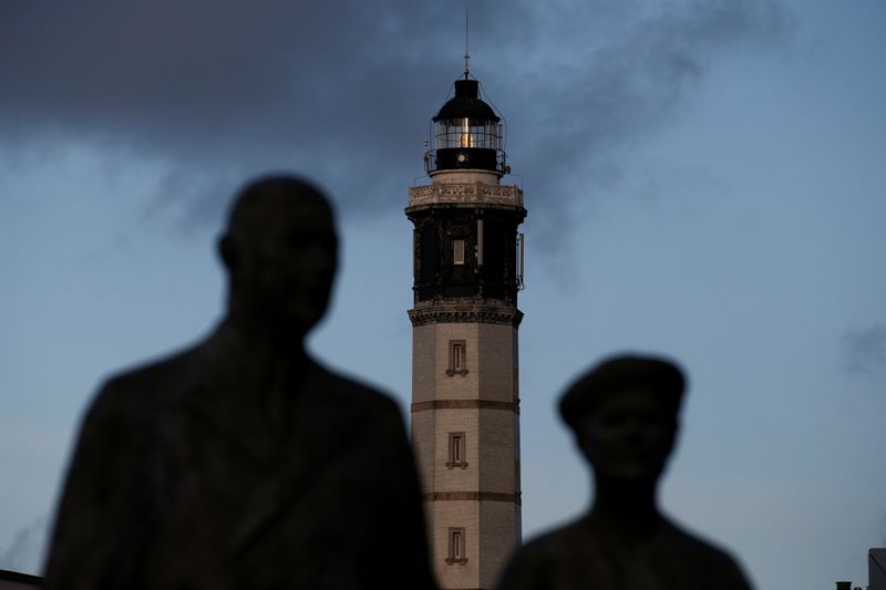 Calais lighthouse appears behind the statue of General de Gaulle and his wife in the center