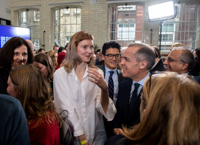 Governor of the Bank of England Mark Carney speaks with British model and actress Lily Cole