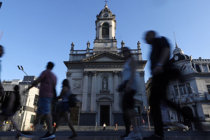 People walk past Pope Francis' old church the Basilica San Jose de Flores, in the district of