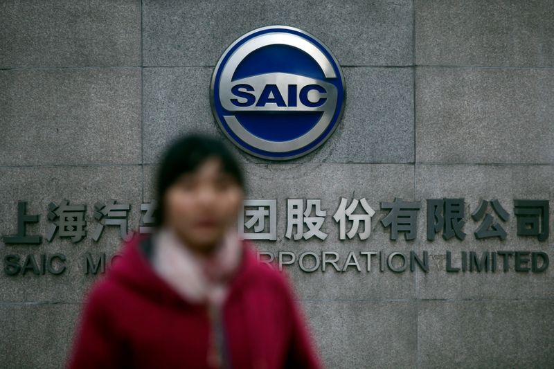 Woman walks past the gate of SAIC Motor Corporation Limited in Shanghai