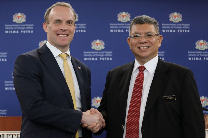Britain's foreign secretary Dominic Raab shakes hands with Malaysia's Foreign Minister