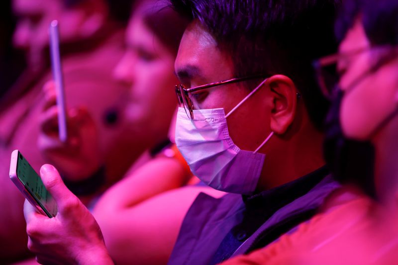 Attendees look at a Samsung Galaxy S20 Ultra 5G smartphone during Samsung Galaxy Unpacked 2020