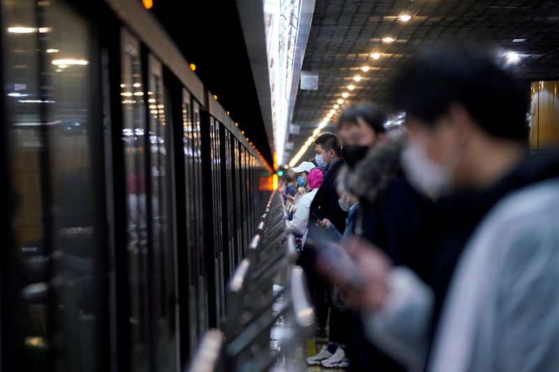 FILE PHOTO: People wearing face masks are seen at a subway station in the morning after the
