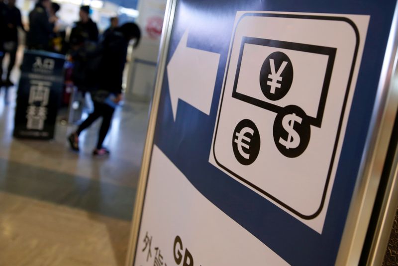Currency signs of Japanese Yen, Euro and the U.S. dollar are seen on a board outside a currency
