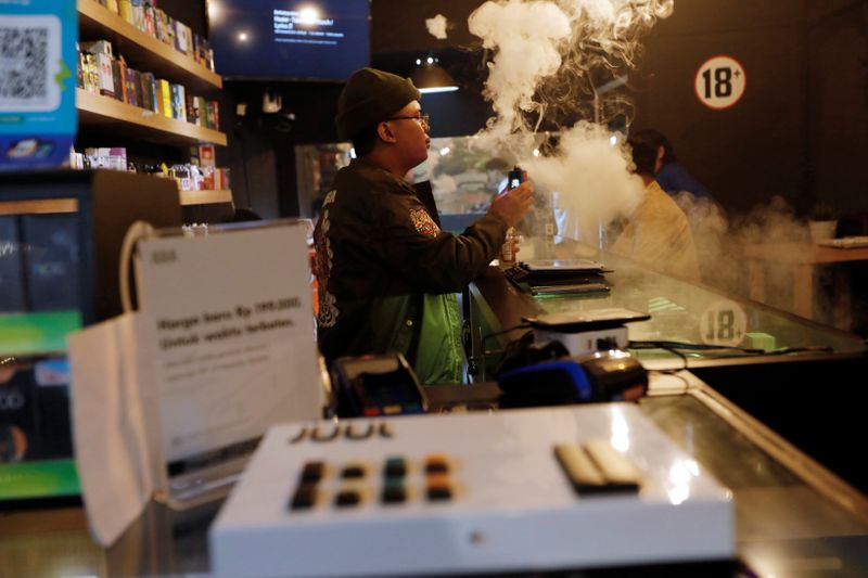 A man tests a vape as Juul brand vaping products are displayed at the Showroom vape shop in