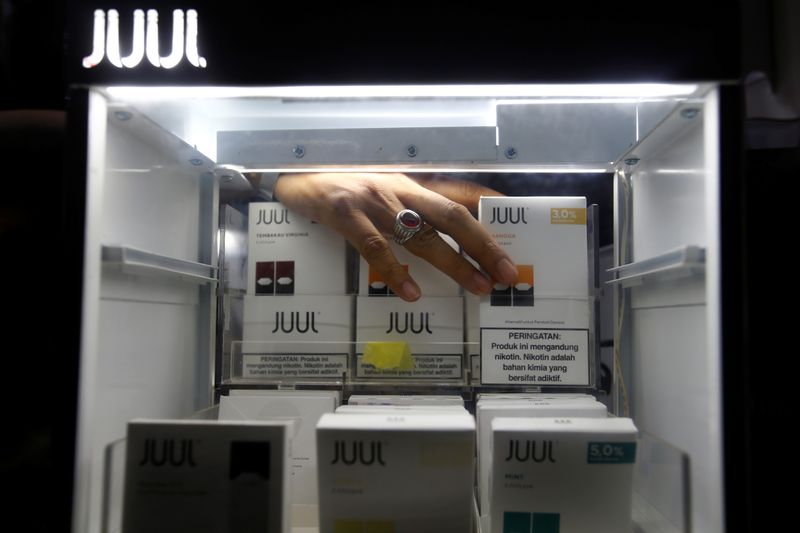 A shopkeeper arranges catridges for Juul brand vaping product at a vape shop in Jakarta