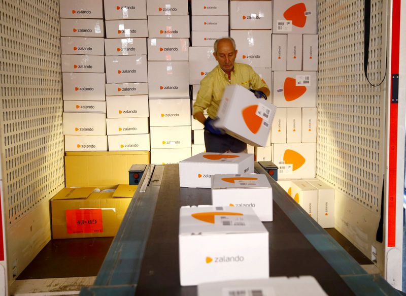 FILE PHOTO: An employee places parcels of online mail order company Zalando on a conveyor at