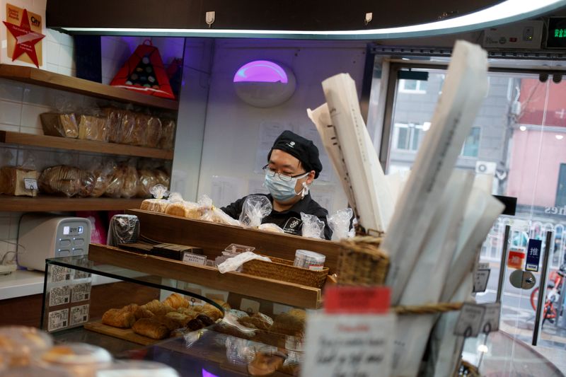 A delivery driver picks up a cake at a cafe of the French bakery Comptoirs de France in Beijing