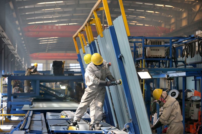 People work inside a factory of a shipbuilding industrial park at a port in Qidong city of