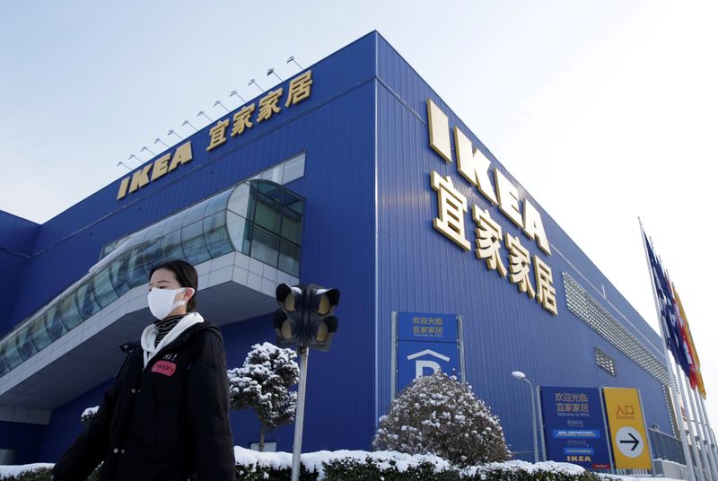 FILE PHOTO: Woman wearing a face mask walks past a closed IKEA store in Beijing