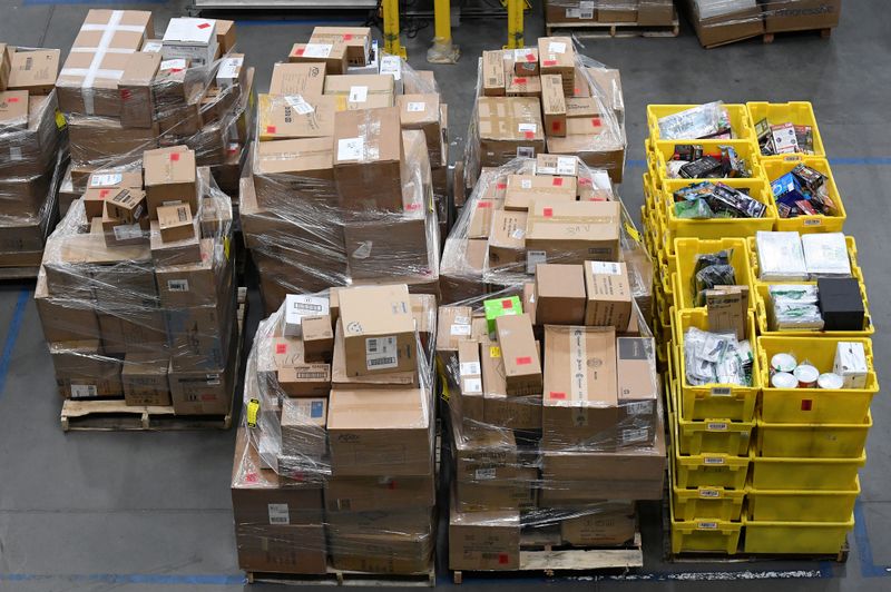 FILE PHOTO: Worker gathers items for delivery from the warehouse floor at Amazon's distribution