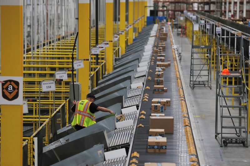 FILE PHOTO: Amazon packages are pushed onto ramps leading to delivery trucks by a robotic