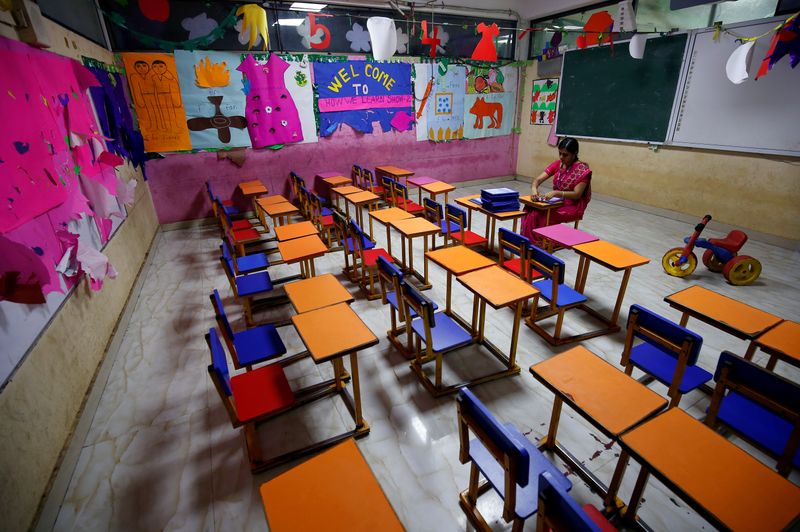 FILE PHOTO: A teacher sits in an empty classroom after Tamil Nadu state government ordered the