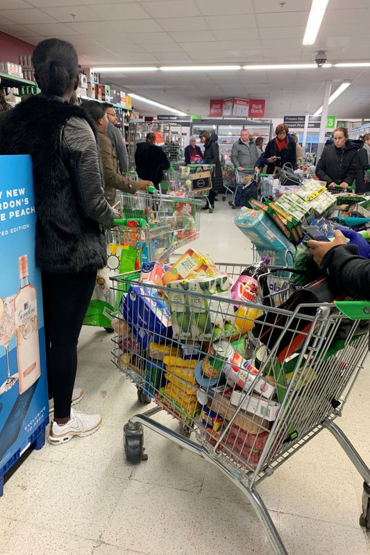 Shoppers queue at a supermarket in London