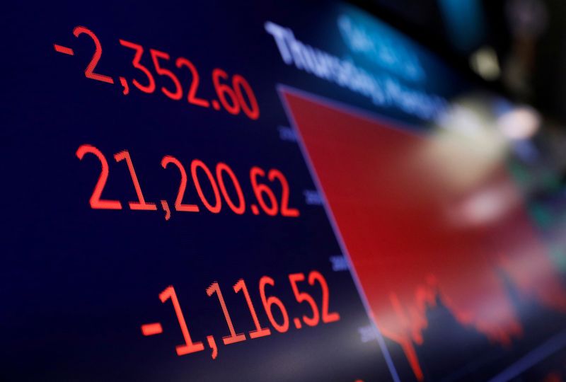 FILE PHOTO: A trader walks from the floor of the New York Stock Exchange (NYSE) after the close