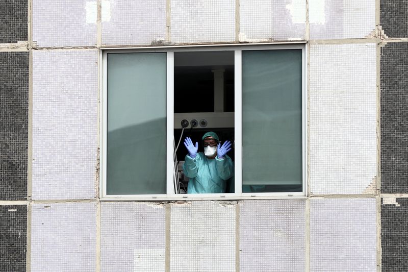 Medical staff in protective gear wave from the Intensive Care Unit of La Paz Hospital in Madrid