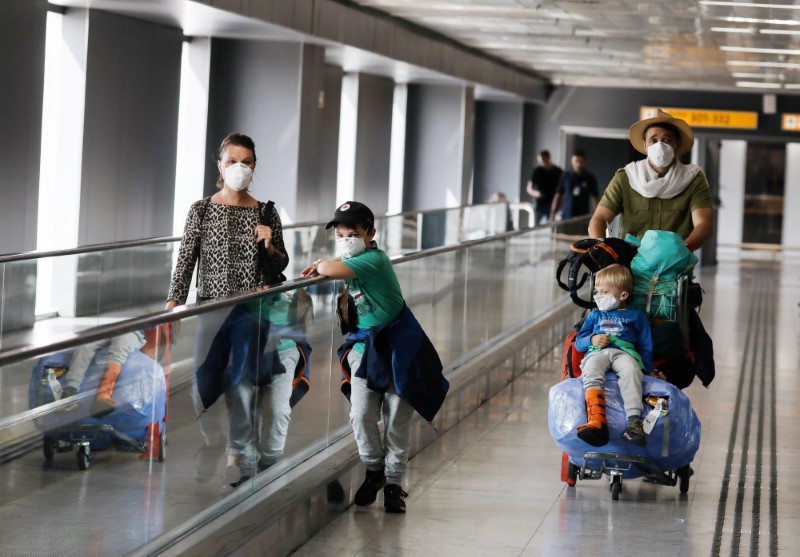 A family wears protective face masks at international arrivals area at Guarulhos International