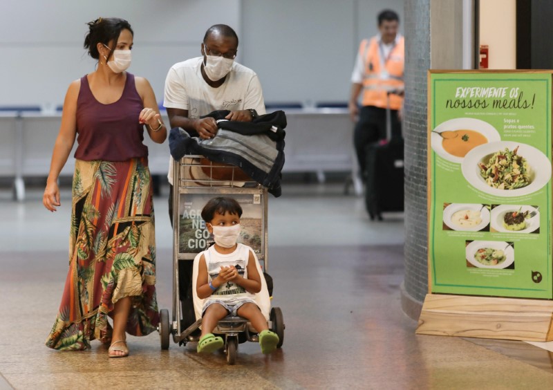 A family wears protective face masks at international arrivals area at Guarulhos International
