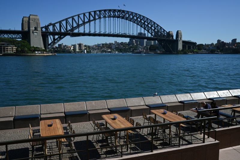 Tables at an open restaurant are seen mostly deserted on a quiet morning at the waterfront of