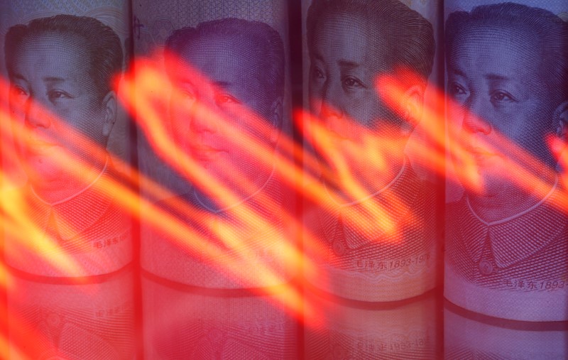 FILE PHOTO: Chinese Yuan banknotes are seen behind illuminated stock graph in this illustration