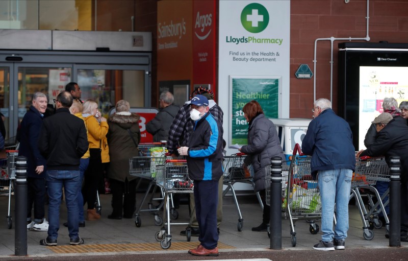FILE PHOTO: People queue outside a supermarket during the spread of coronavirus disease