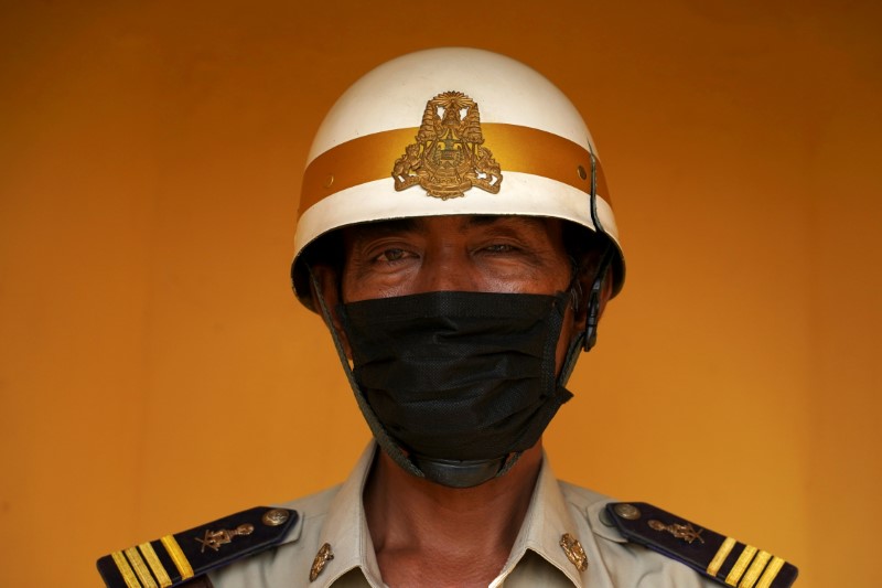A Chinese woman, wearing full protective gear to prevent contracting the coronavirus, waits for