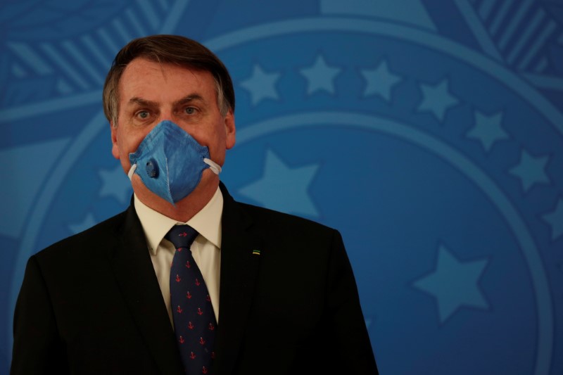 Brazil's President Jair Bolsonaro wears a protective mask during a news conference, amid