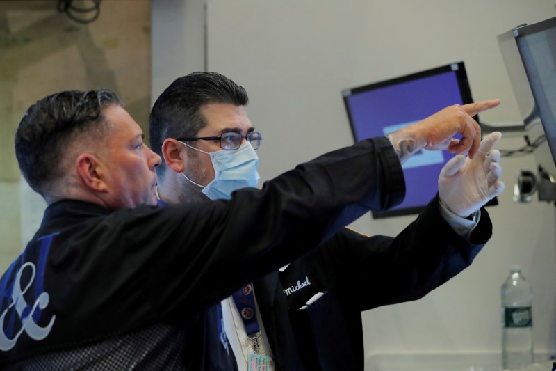 FILE PHOTO: Traders work on the floor of the New York Stock Exchange (NYSE) as the building