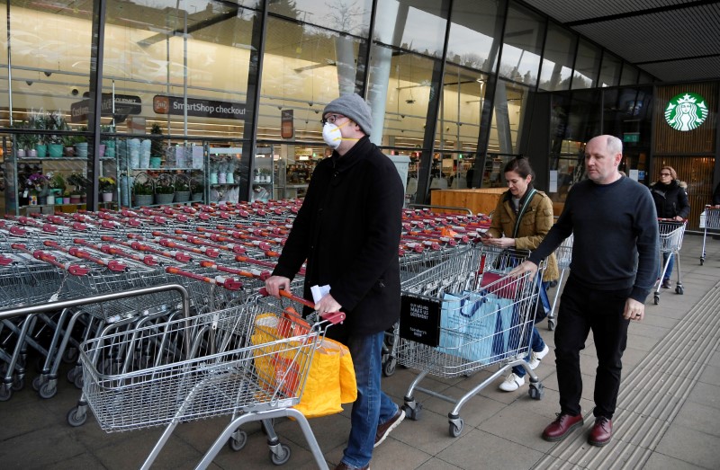Shoppers queue to enter a Sainsbury's supermarket in West London