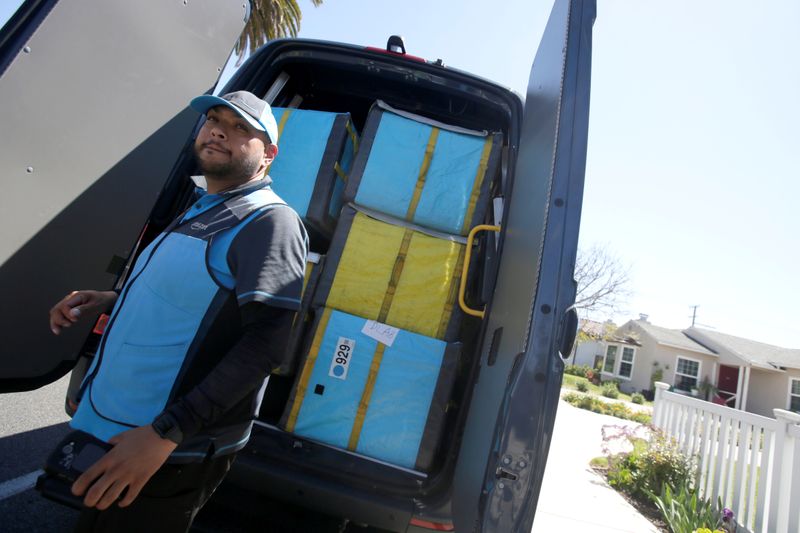 Joseph Alvarado picks up a package while making deliveries for Amazon during the outbreak of