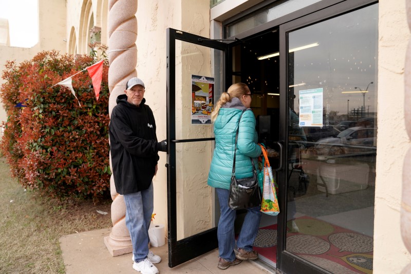 Chlebanowski looks for a customer's apartment to deliver produce in Norman