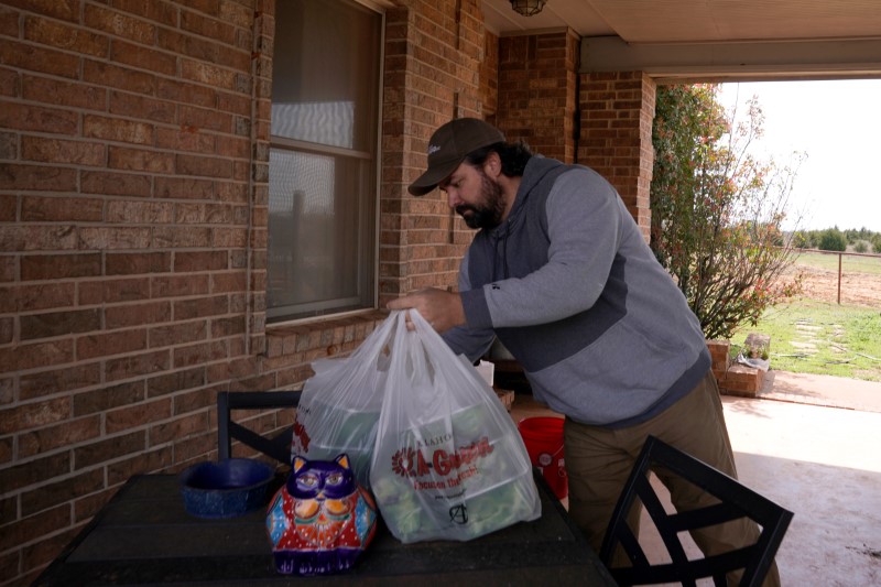 Meir buys produce from Taylor while wearing a mask at the Farmers Public Market in Oklahoma